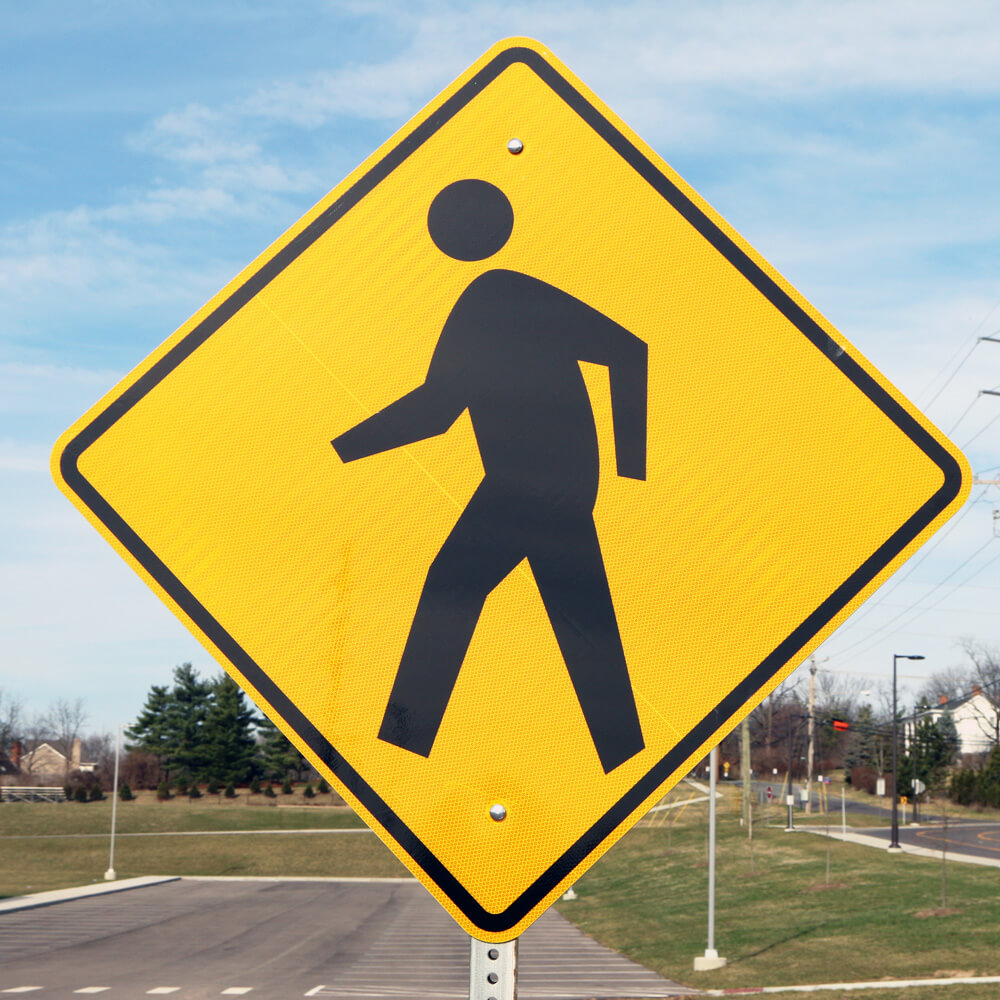 Pedestrian crossing road traffic sign showing a person on a zebra